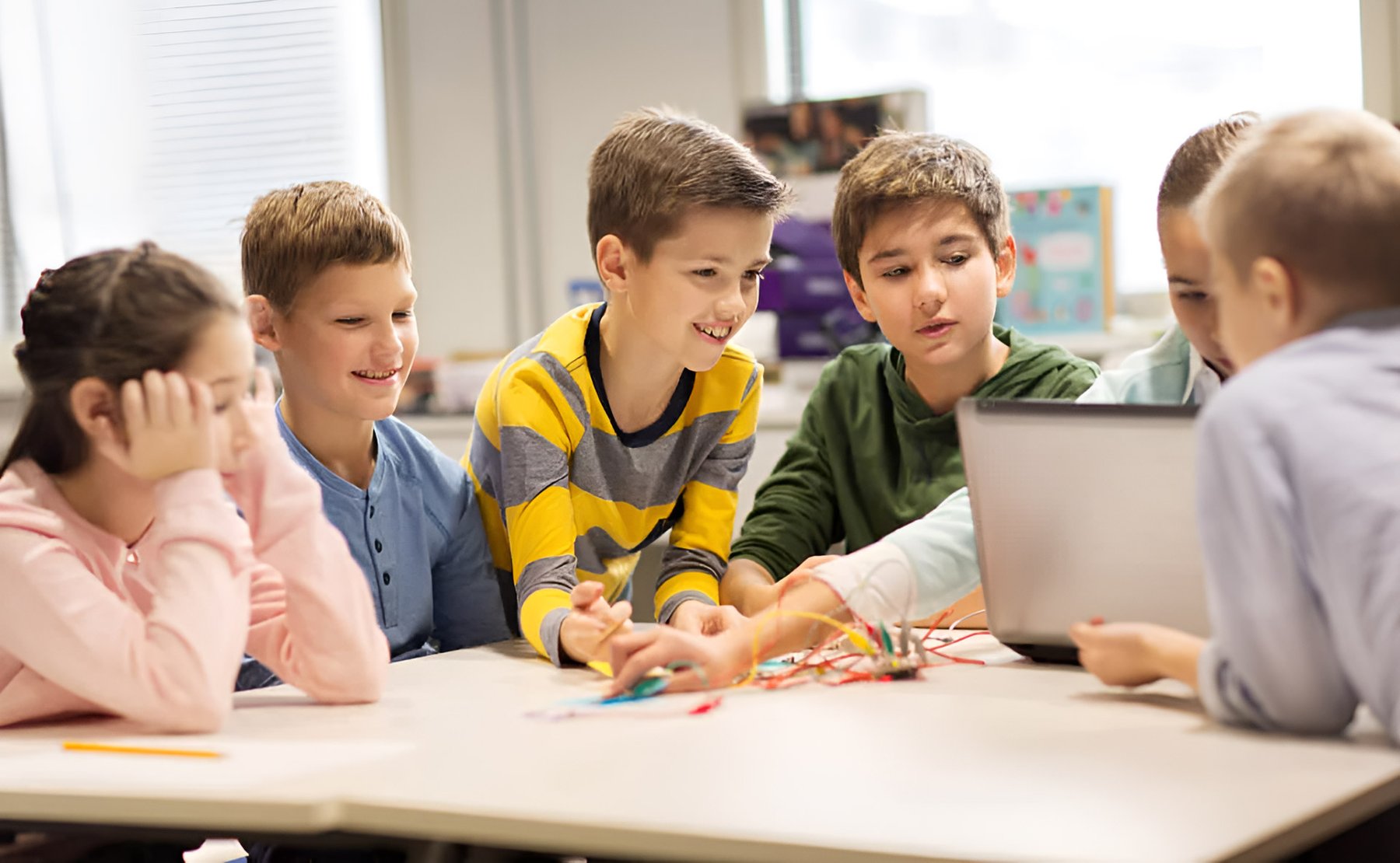Kinder arbeiten gemeinsam an einem Laptop in der Grundschule MV Ganztagsschule Rostock