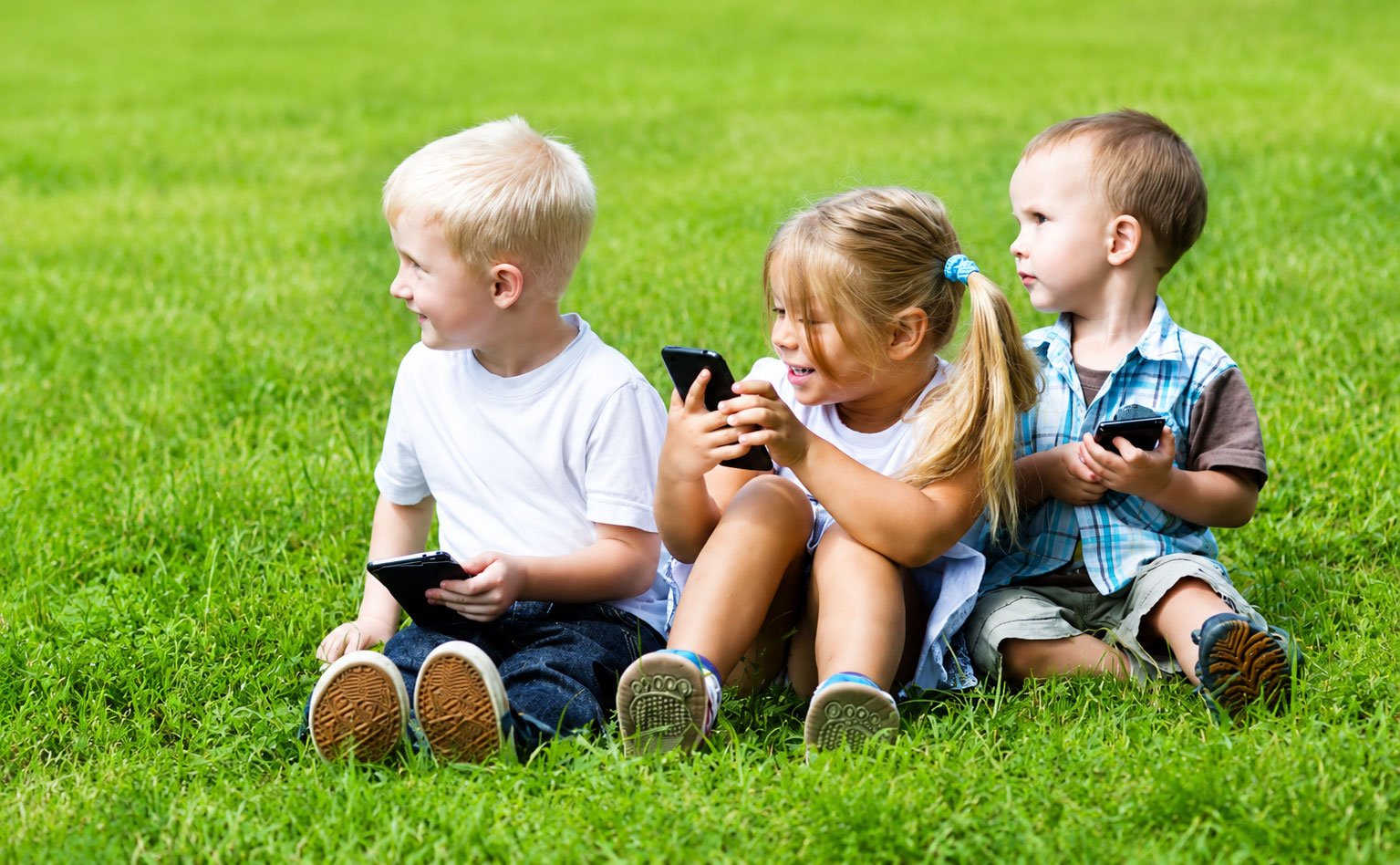 Kinder spielen mit Smartphones im Freien Kita Rostock
