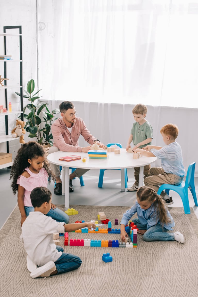 Erzieher Job Pädagogische Fachkraft arbeitet bei ILL mit Kindern am Tisch