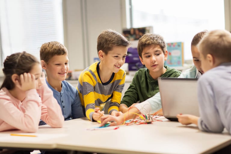 Kinder arbeiten gemeinsam an einem Laptop in der Grundschule MV Ganztagsschule Rostock