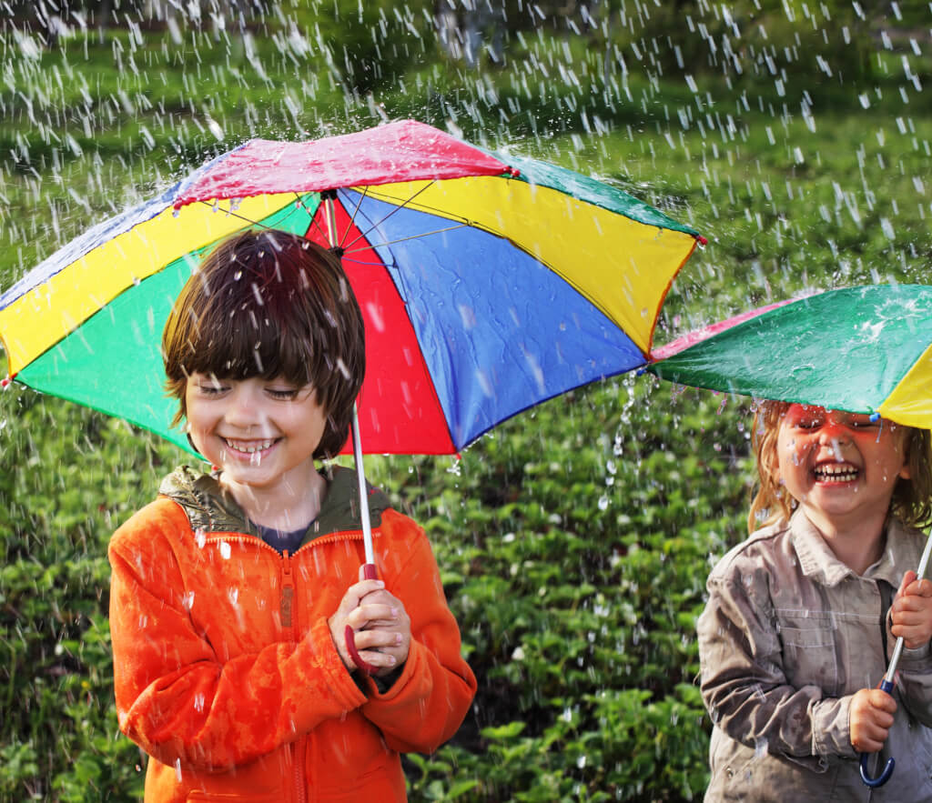 Kinder mit bunten Regenschirmen im Regen fröhlich Kita Rostock Kreativitätspädagogik MV